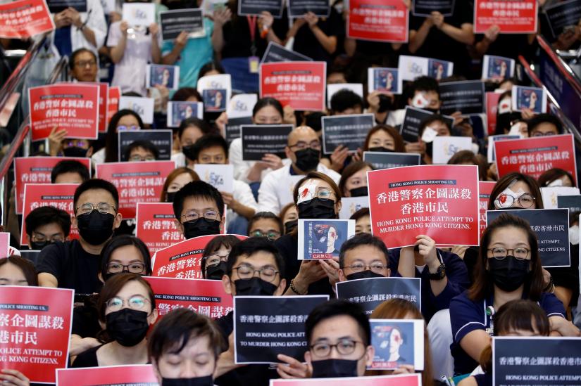 Medical staff hold placards during a picket denouncing police brutality during recent anti-government protests, at Queen Elizabeth Hospital in Hong Kong, China August 13, 2019. REUTERS