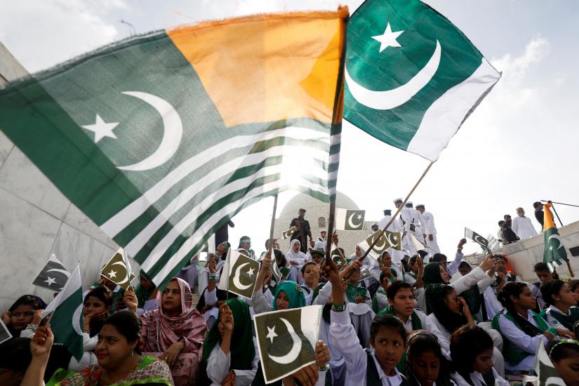 Attendees wave Pakistan`s national flag and Kashmir`s flag, to express solidarity with the people of Kashmir, during a ceremony to celebrate Pakistan`s 72nd Independence Day at the Mausoleum of Muhammad Ali Jinnah in Karachi, Pakistan August 14, 2019. REUTERS