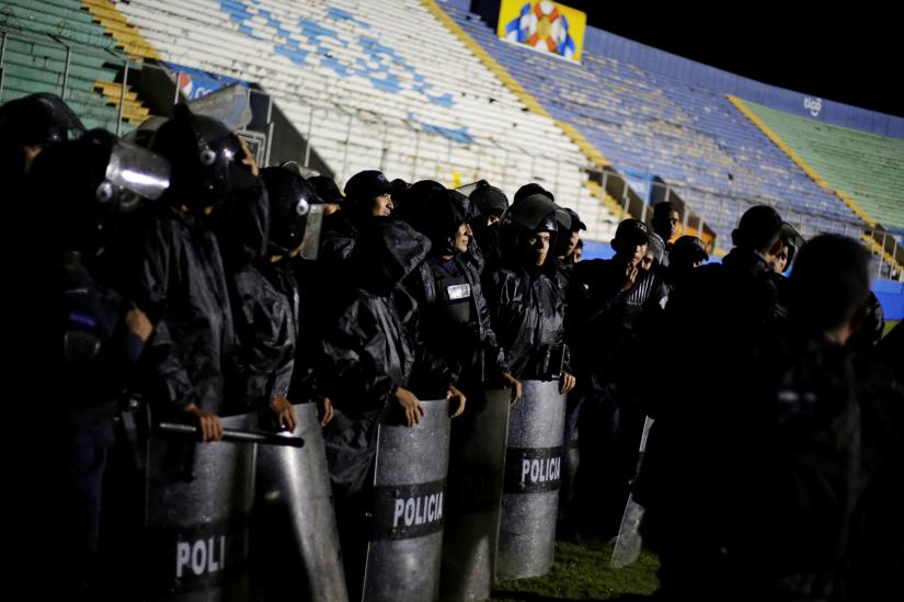 Police officers keep watch after three people died in riots before a soccer match when the fans attacked a bus carrying one of the teams, inside the National Stadium in Tegucigalpa, Honduras August 17, 2019. REUTERS
