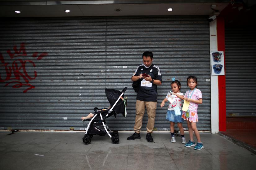 A family takes part in the `Reclaim Hung Hom and To Kwa Wan, Restore Tranquility to Our Homeland` demonstration against the extradition bill in To Kwa Wan neighborhood, Hong Kong, China August 17, 2019. REUTERS