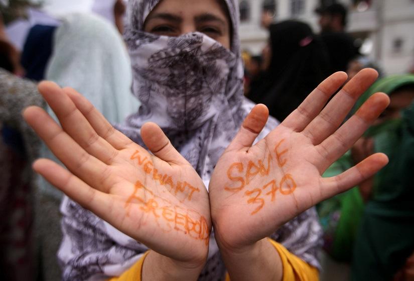 A Kashmiri woman shows her hands with messages at a protest after Friday prayers during restrictions after the Indian government scrapped the special constitutional status for Kashmir, in Srinagar August 16, 2019. REUTERS