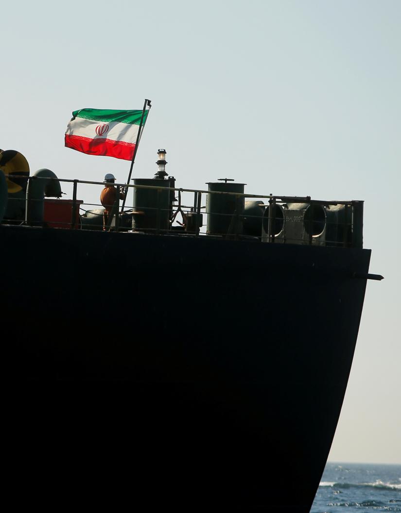 A crew member raises the Iranian flag on the Iranian oil tanker Adrian Darya 1, previously named Grace 1, as it sits anchored after the Supreme Court of the British territory lifted its detention order, in the Strait of Gibraltar, Spain, August 18, 2019. REUTERS