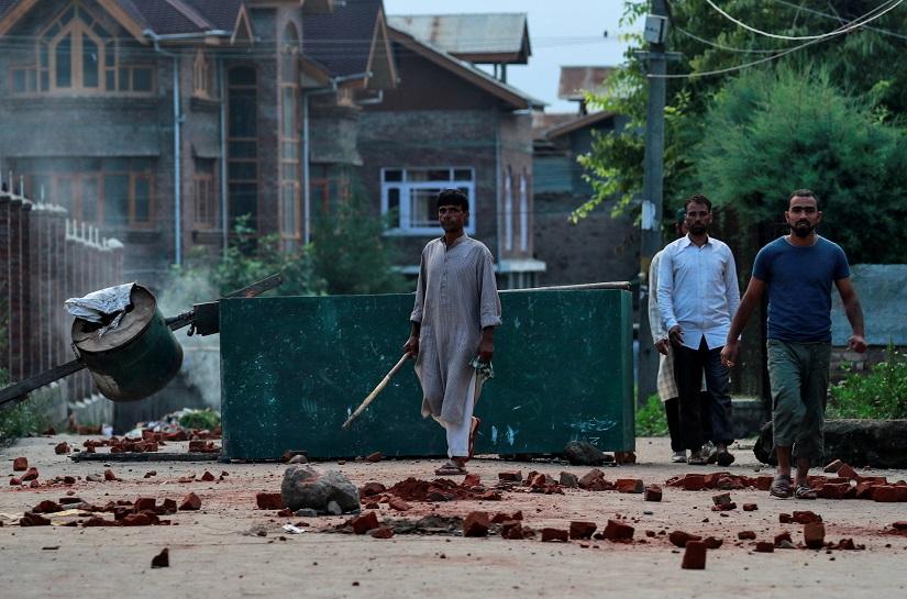 FILE PHOTO: Kashmiris walk past a blockade put up by residents to prevent security personnel from sealing off a mosque ground ahead of Eid-al-Adha prayers during restrictions following the scrapping of the special constitutional status for Kashmir by the Indian government, in Srinagar, August 12, 2019. REUTERS