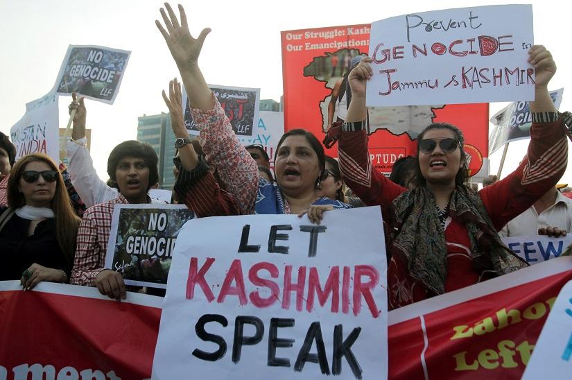 People carry signs as they chant slogans to express solidarity with the people of Kashmir, during a rally in Lahore, Pakistan, Aug 20, 2019. REUTERS