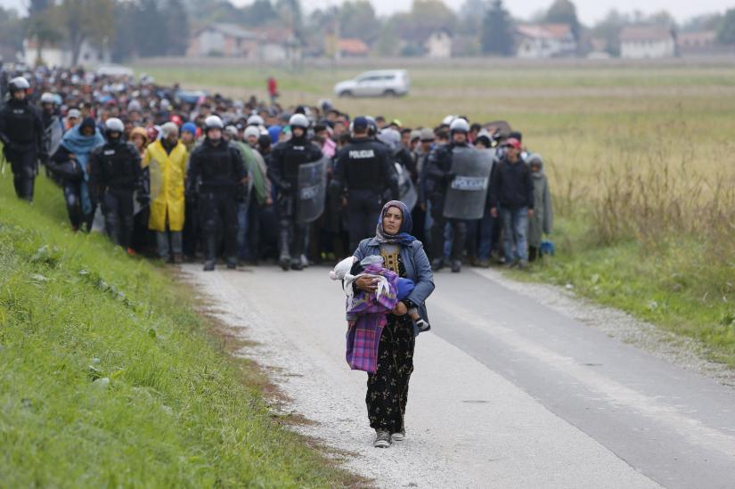 Police officers escort Fatima from Syria, front, and hundreds of other migrants as they make their way on foot after crossing into Slovenia from Croatia on  October 23, 2015. REUTERS/File Photo