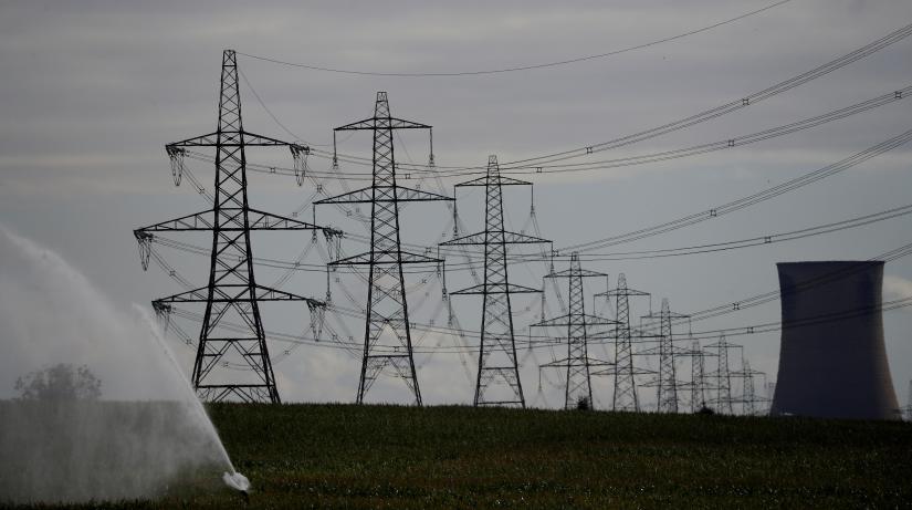Electricity pylons and a cooling tower from Eggborough power station are seen above a farmers` field in Kellingley, Britain August 1, 2018. REUTERS/File Photo