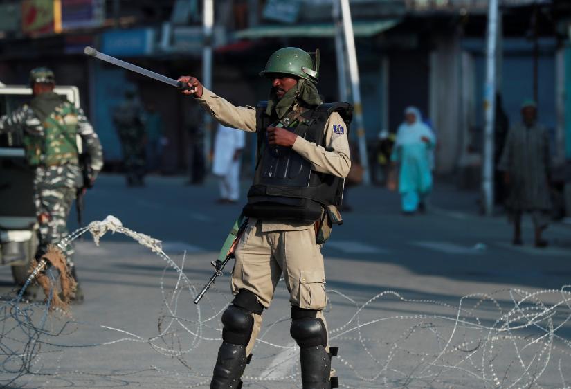 An Indian security personnel stops movement of vehicles at a blockade during restrictions after scrapping of the special constitutional status for Kashmir by the Indian government, in Srinagar, August 23, 2019. REUTERS