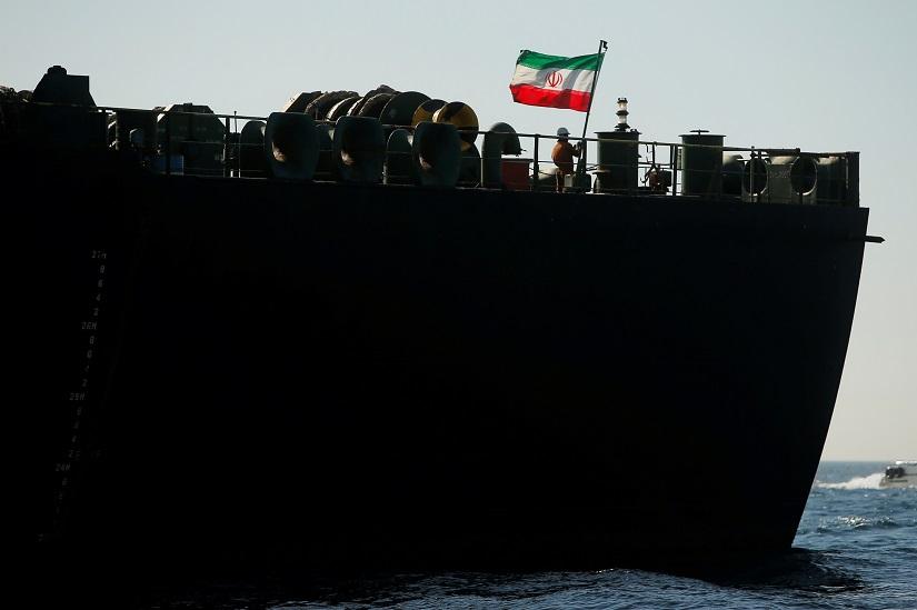 A crew member raises the Iranian flag on Iranian oil tanker Adrian Darya 1, previously named Grace 1, as it sits anchored after the Supreme Court of the British territory lifted its detention order, in the Strait of Gibraltar, Spain, Aug 18, 2019. REUTERS