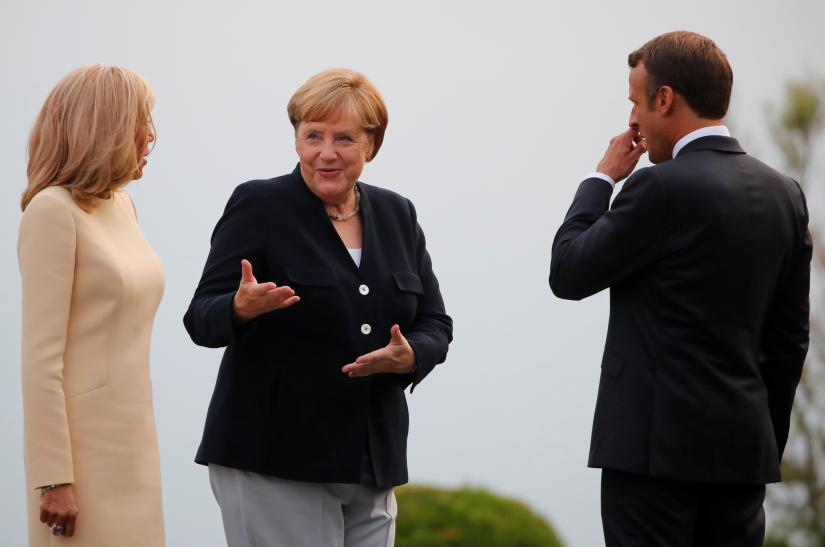 French President Emmanuel Macron and his wife Brigitte Macron welcome German Chancellor Angela Merkel as she arrives for a banquet during the G7 summit in Biarritz, France, August 24, 2019. REUTERS