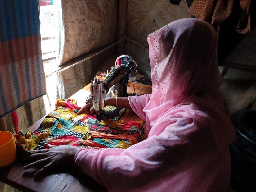 Shofika Begum, a Rohingya who was raped two years ago in Myanmar and today leads a group of female tailors in the refugee camps in South East Bangladesh who sell clothes for a living, stitches a dress at her home on August 5, 2019. Thomson Reuters Foundation