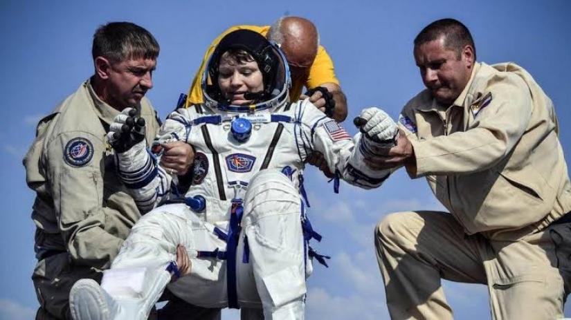 Anne McClain is helped from a space capsule after returning from the ISS in June REUTERS