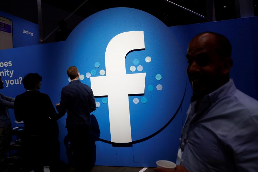 Attendees walk past a Facebook logo during Facebook Inc`s F8 developers conference in San Jose, California, U.S., April 30, 2019. REUTERS/File Photo