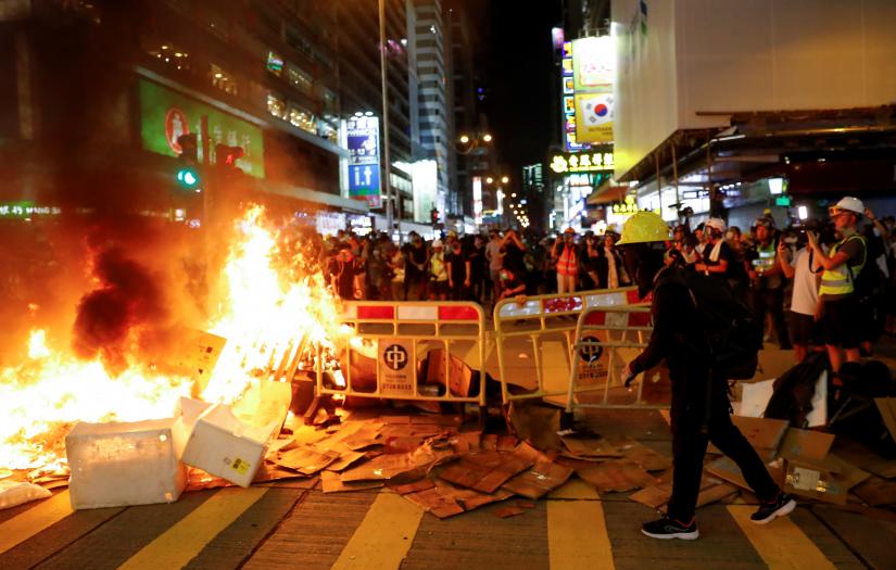 Protestors stand behind a burning barricade during a demonstration in Mong Kok district in Hong Kong, China September 6, 2019. REUTERS