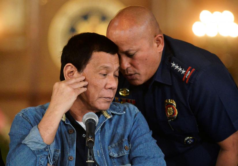 FILE PHOTO: Philippine National Police chief General Ronald Dela Rosa whispers to President Rodrigo Duterte during the announcement of the disbandment of police operations against illegal drugs at the Malacanang palace in Manila, Philippines January 29, 2017. REUTERS