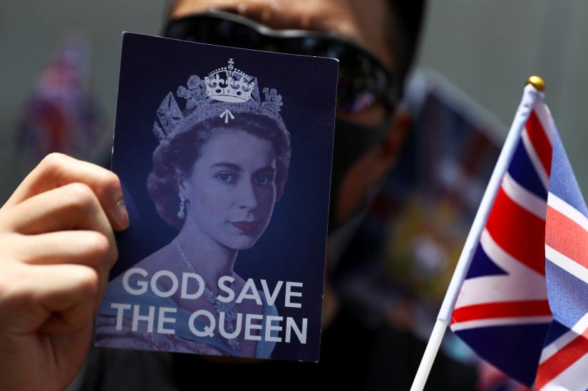 An anti-government protester holds up a Union Jack flag and a placard with a likeness of Queen Elizabeth at the British consulate General in Hong Kong, China, September 15, 2019. REUTERSTS at UK mission 4