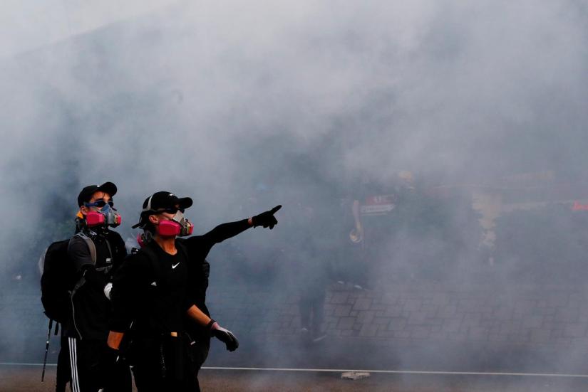 Anti-government protesters react from tear gas during a demonstration near Central Government Complex in Hong Kong, China Sept 15, 2019. REUTERS
