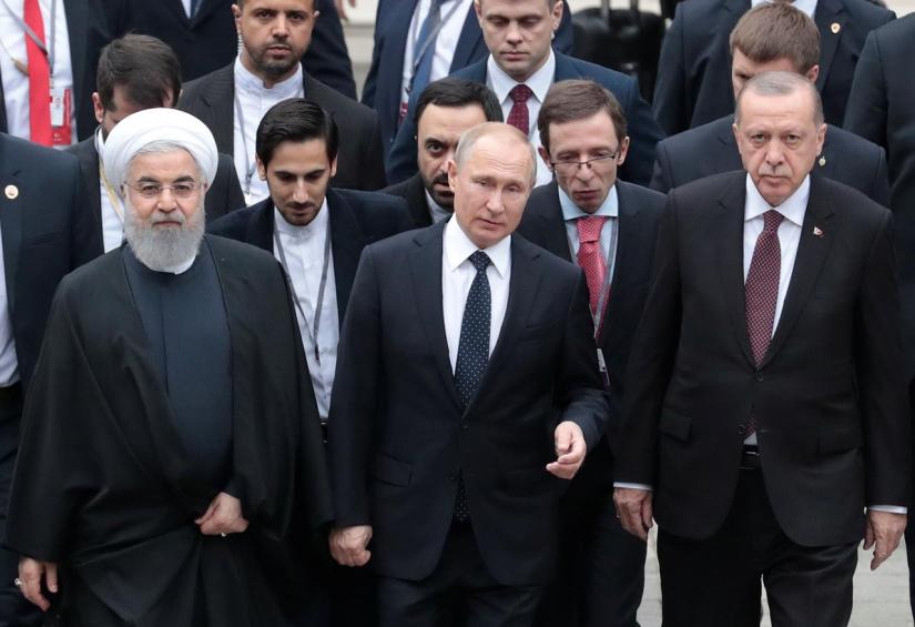 FILE PHOTO - Iranian President Hassan Rouhani, Russian President Vladimir Putin and Turkish President Recep Tayyip Erdogan walk during their meeting in the Black sea resort of Sochi, Russia, 14 Feb 2019. REUTERS