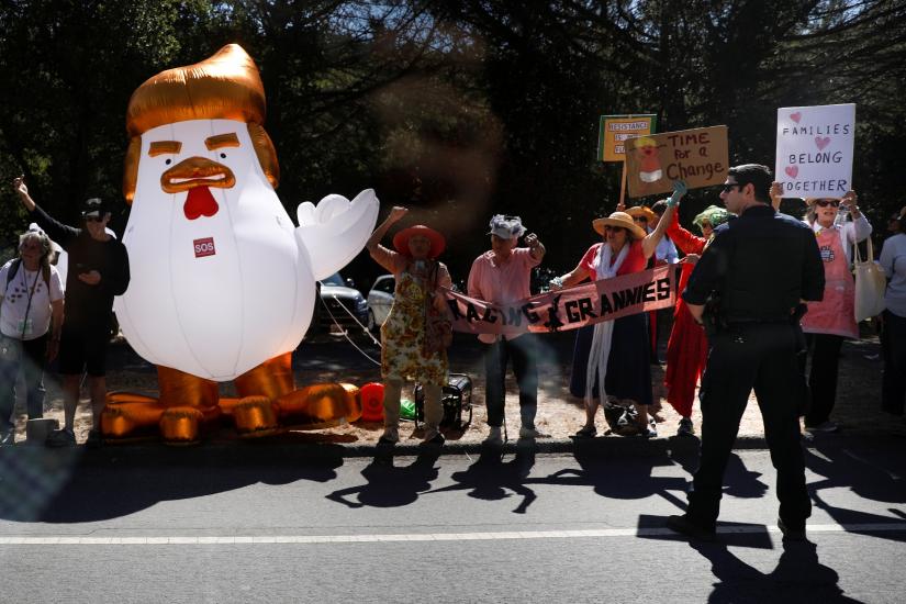 Demonstrators stand beside an inflatable chicken mocking U.S. President Donald Trump as the presidential motorcade passes by in Palo Alto, California, U.S., September 17, 2019. REUTERS