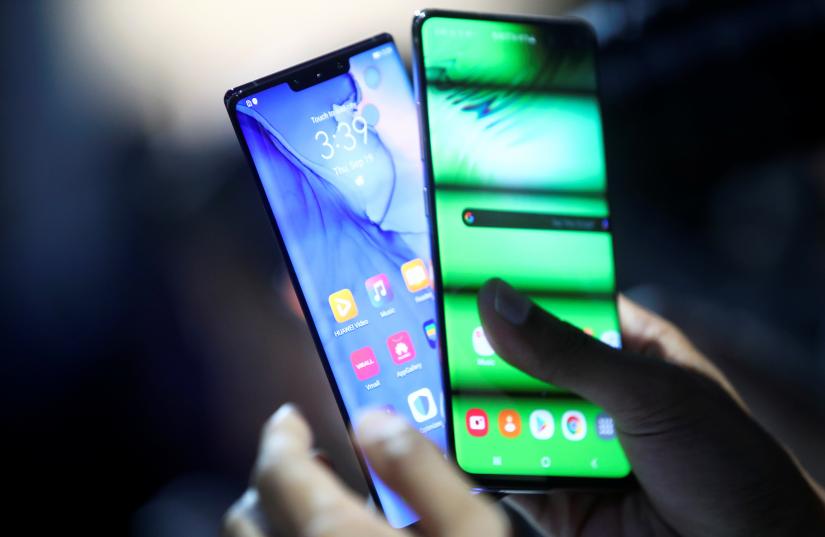 A person holds two new Huawei Mate 30 smartphones at the Convention Center in Munich, Germany September 19, 2019. REUTERS