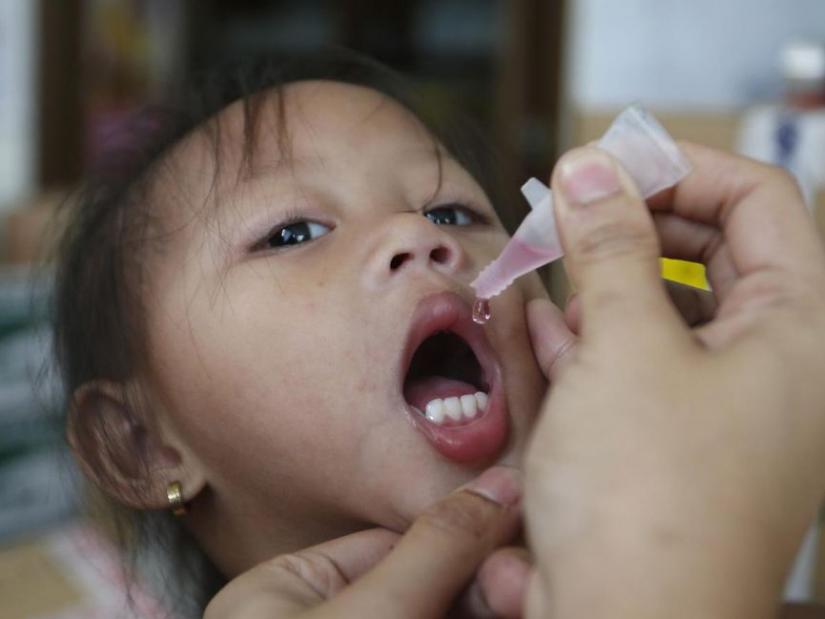 FILE PHOTO: A girl receives anti-measles vaccination drops at a health centre in BASECO compound in Tondo, Manila September 3, 2014. REUTERS