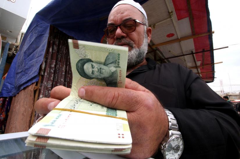 A man buys Iranian rials from a seller of Iranian currency, before the start of the U.S. sanctions on Tehran, in Basra, Iraq November 3, 2018. Picture taken November 3, 2018. REUTERS/File Photo