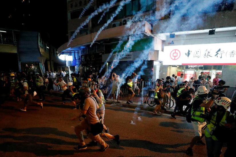 Protesters react to tear gas after a sit-in at Yuen Long to protest against violence that happened two months ago when white-shirted men wielding pipes and clubs wounded both anti-government protesters and passers-by, in Hong Kong, China Sept 21, 2019. REUTERS