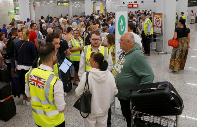 Passengers are seen at Thomas Cook check-in points at Mallorca Airport after the world`s oldest travel firm collapsed stranding hundreds of thousands of holidaymakers around the globe and sparking the largest peacetime repatriation effort in British history, in Palma de Mallorca, Spain, September 23, 2019. REUTERS