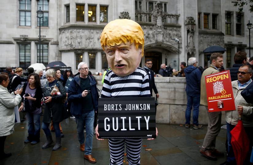 FILE PHOTO: A protester stands outside the Supreme Court of the United Kingdom after the hearing on British Prime Minister Boris Johnson`s decision to prorogue parliament ahead of Brexit, in London, Britain September 24, 2019. REUTERS