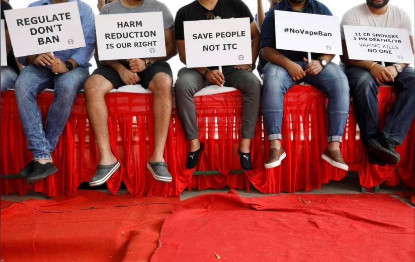 People hold placards during a protest against the ban on the sale, import and manufacture of e-cigarettes by the Indian government, in New Delhi, September 28, 2019. REUTERS