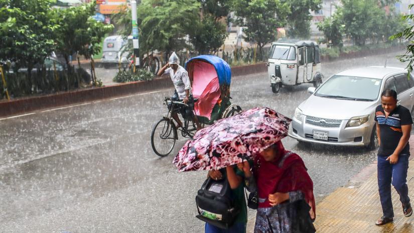 People are seen walking amid downpour in Dhaka on Sunday (Sept 29). PHOTO/Sazzad Hossain