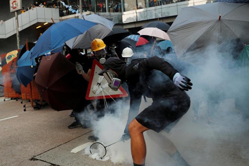 FILE PHOTO-An anti-government protester tries to hit back a tear gas canister at riot police with his badminton racket, during a demonstration at Admiralty district in Hong Kong, China Sept 29, 2019. REUTERS