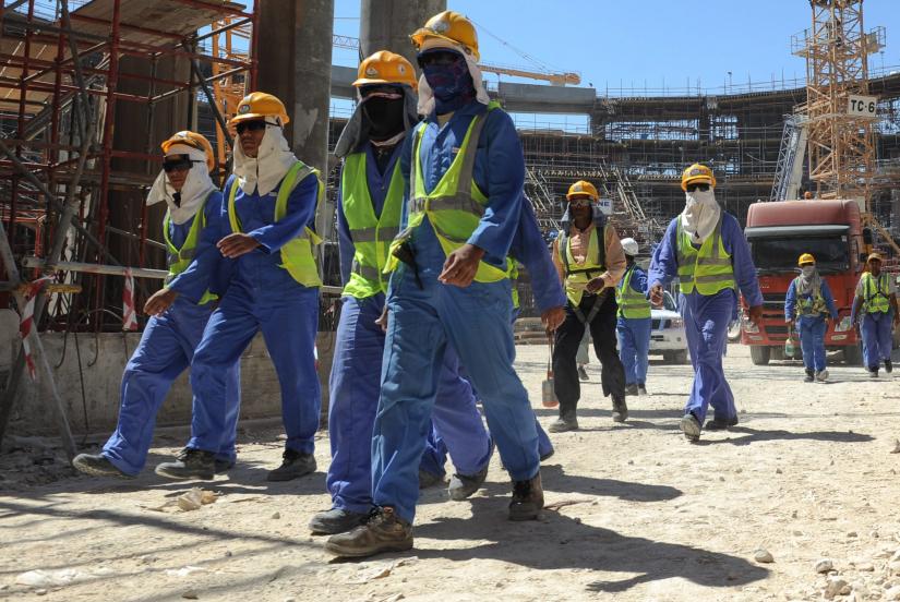 Foreign labourers leave a construction site in Qatar.