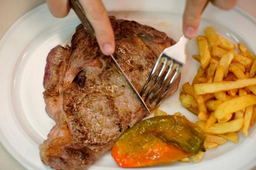 A beef steak is cut at the Taberna del Gijon restaurant in Madrid, Spain, July 26, 2017. REUTERS