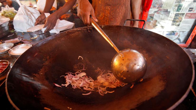 FILE PHOTO: A cook fries onions to put into vegetable chowmein at a beachside restaurant in Mumbai, India, Jan 28, 2011. REUTERS