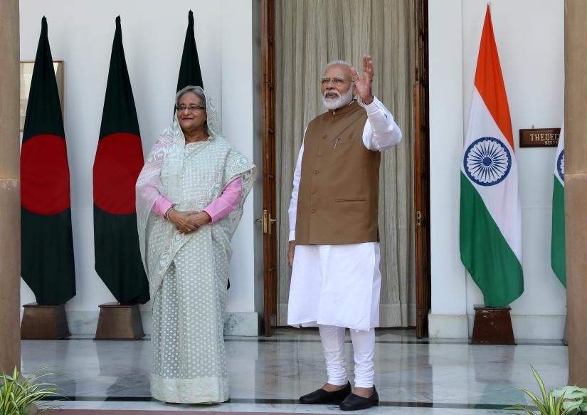 India`s Prime Minister Narendra Modi waves to the media next to his Bangladeshi counterpart Sheikh Hasina before their meeting at Hyderabad House in New Delhi, India, October 5, 2019. REUTERS