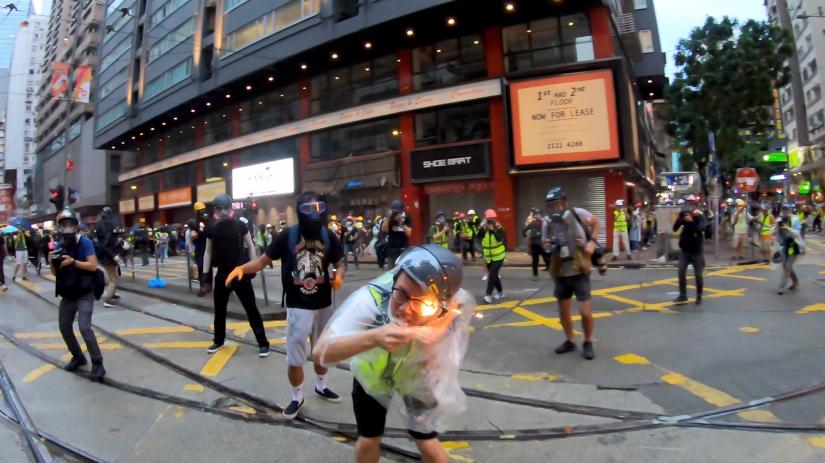 Flames by a molotov cocktail can been seen on a journalist during a protest in Wan Chai, Hong Kong, China October 6, 2019, in this still image obtained from a social media video. Angus Wong Chun Yiu/via REUTERS