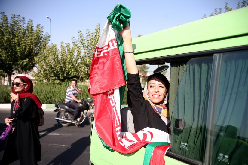 An Iranian woman holds Iranian flags as she arrives to attend Iran’s FIFA World Cup Asian qualifier match against Cambodia, as for the first time women are allowed to watch the national soccer team play in over 40 years, at the Azadi stadium in Tehran, Iran October 10, 2019.  WANA (West Asia News Agency) via REUTERS