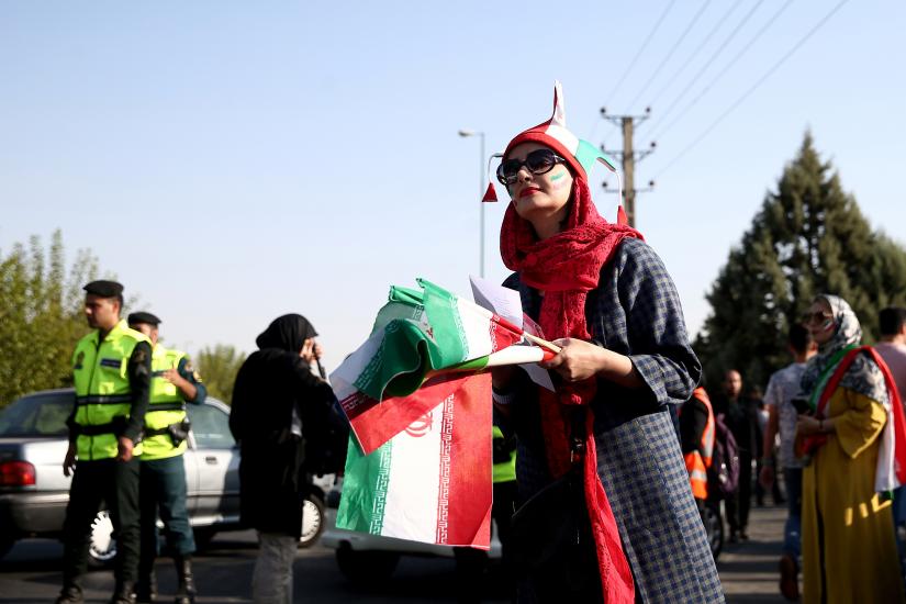 An Iranian woman holds the Iranian flag as she arrives to attend Iran’s FIFA World Cup Asian qualifier match against Cambodia, as for the first time women are allowed to watch the national soccer team play in over 40 years, at the Azadi stadium in Tehran, Iran October 10, 2019.  WANA (West Asia News Agency) via REUTERS