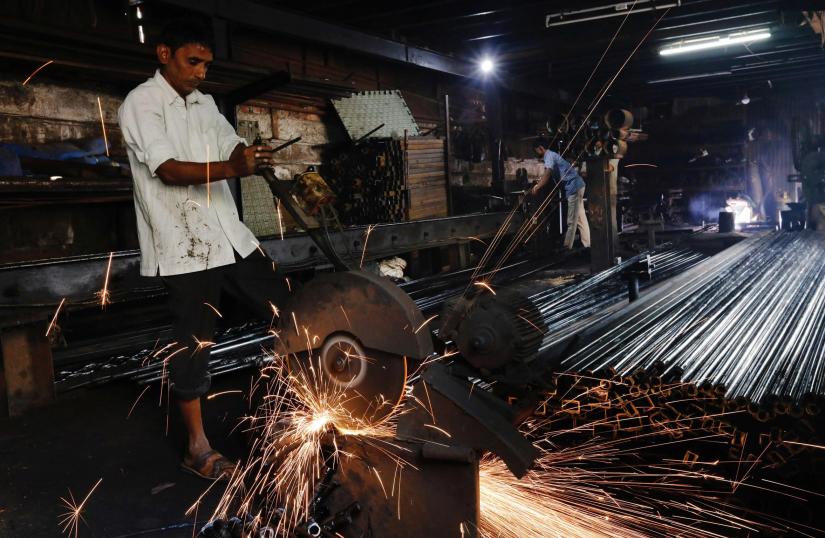 Workers make pipes used for drilling, at a factory in an industrial area in Mumbai, January 29, 2018. REUTERS/File Photo