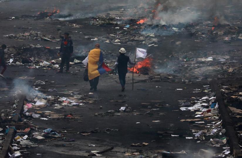 People walk on the street in the aftermath of last days protests against Ecuador`s President Lenin Moreno`s austerity measures, after Moreno imposed a military-enforced curfew in the capital Quito, Ecuador Oct 13, 2019. REUTERS