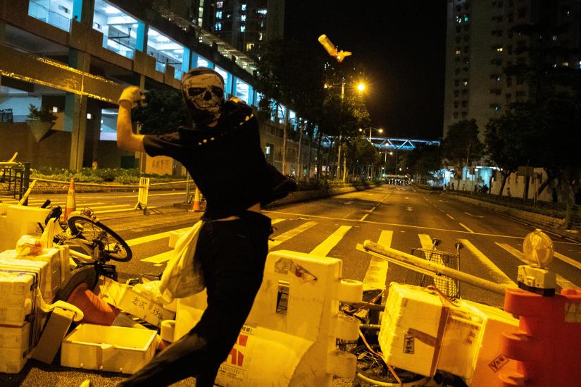 Anti-govenrment protesters throws a molotov cocktail toward riot police officers during a protest at Tseung Kwan O district, in Hong Kong, China, Oct 13, 2019. REUTERS