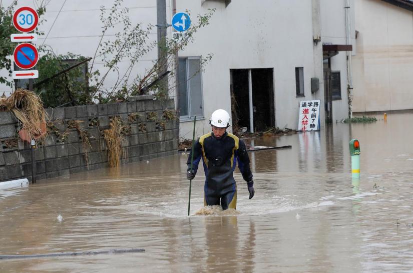 A rescue worker wades in water in the aftermath of Typhoon Hagibis, which caused severe floods, near the Chikuma River in Nagano Prefecture, Japan, Oct 14, 2019. REUTERS