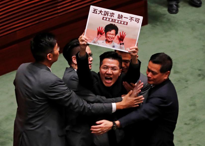 A pro-democracy lawmaker is escorted by security from the Legislative Council, as Hong Kong's Chief Executive Carrie Lam takes questions from lawmakers regarding her policy address, in Hong Kong, China October 17, 2019. REUTERS/