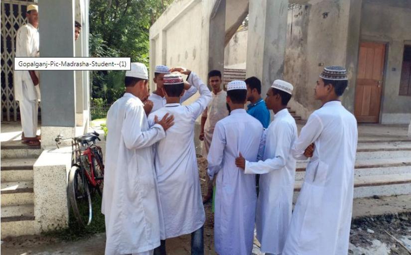 Some students of Kushla Nesaria Senior Fazil Madrasa of Kotalipara upazila seen standing in front of the institution