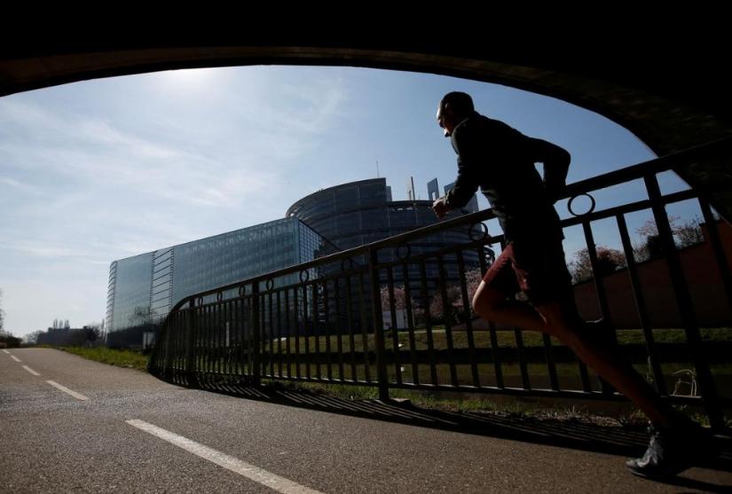 FILE PHOTO: A jogger runs in front of the building of the European Parliament, designed by Architecture-Studio architects, in Strasbourg, France, March 22, 2019. REUTERS
