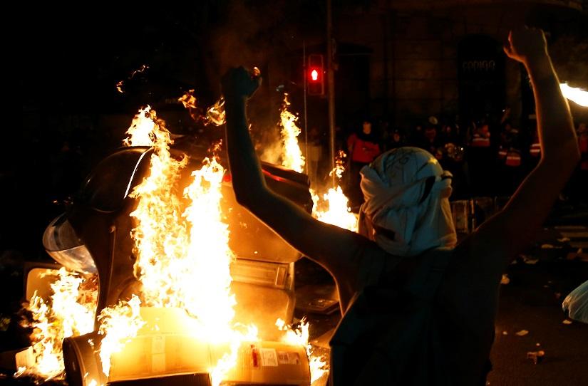 A separatist supporter reacts in front of a fire during a protest after a verdict in a trial over a banned independence referendum in Barcelona, Spain, Oct 17, 2019. REUTERS