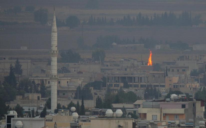 A fire is seen in the Syrian town of Ras al-Ain as seen from the Turkish border town of Ceylanpinar, Sanliurfa province, Turkey, Oct 17, 2019. REUTERS