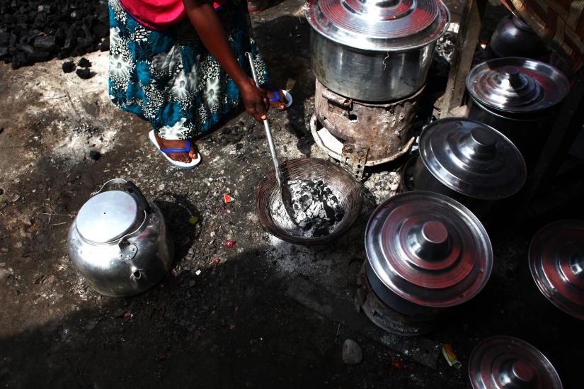 A woman adjusts the charcoal in a stove next to cooking pots at a village about 30 km south of South Sudan`s capital Juba June 21, 2013. South Sudanese people use charcoal as their main source of energy. REUTERS/File Photo
