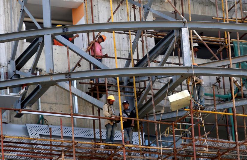 Labourers work on a new building at a construction site in Phnom Penh, Cambodia October 25, 2017. REUTERS/File Photo