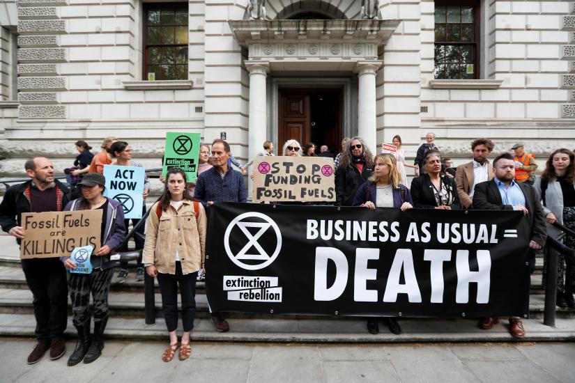 Climate protesters hold placards in front of HM Treasury in Westminster during the Extinction Rebellion protest in London, Britain April 25, 2019. REUTERS